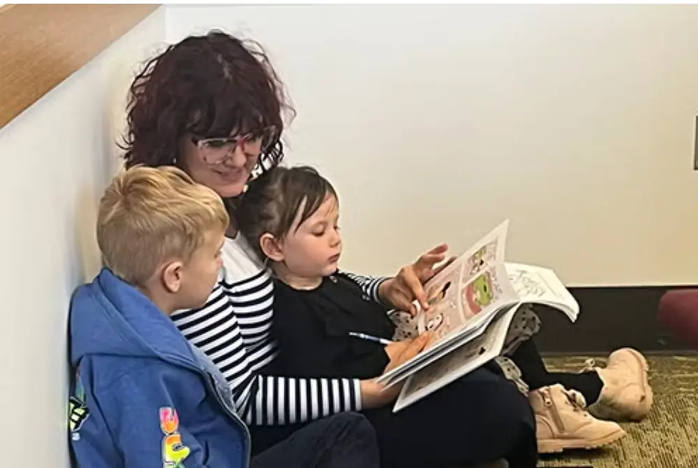 Mroz reading a French book to two kids
